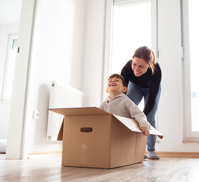 Woman and child playing with box in new home